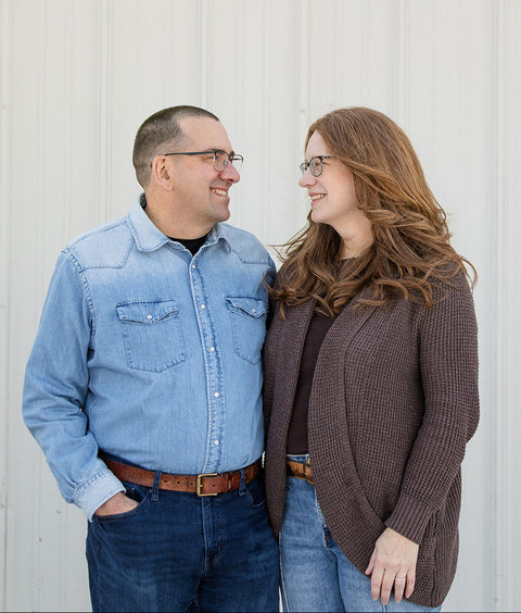 Two people standing side by side against a light gray background